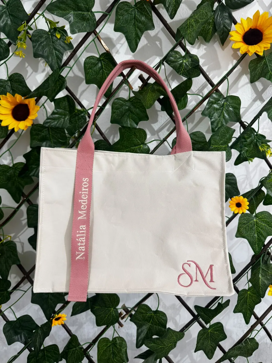 Bolsa cru modelo Clássica com alça rosa bordada “Natália Medeiros” e monograma SM