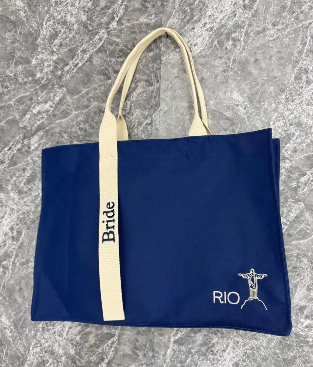 Bolsa azul royal com alça cru bordada “Bride” e o Cristo Redentor com a palavra RIO