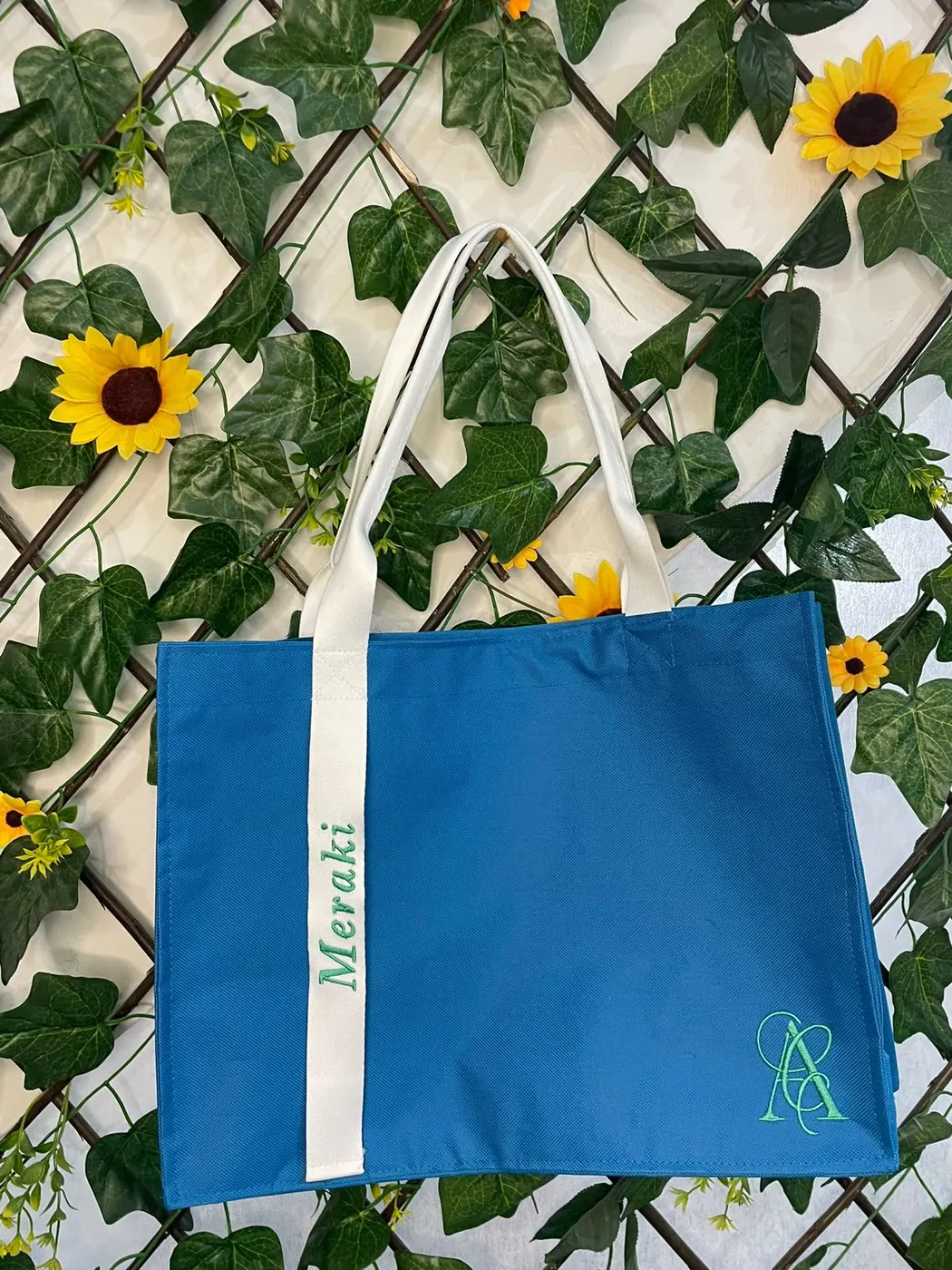 Bolsa azul turquesa com alça branca bordada “Meraki” em verde